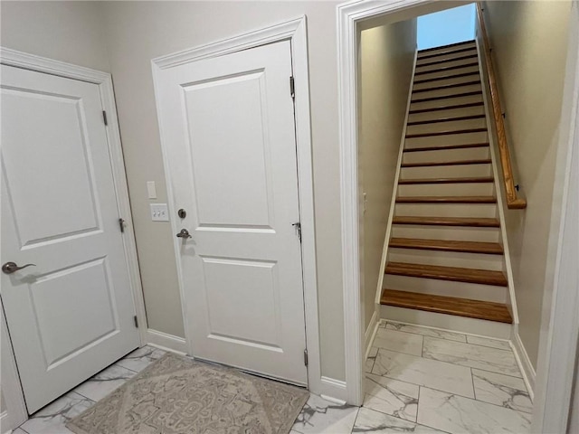 stairway featuring baseboards and marble finish floor