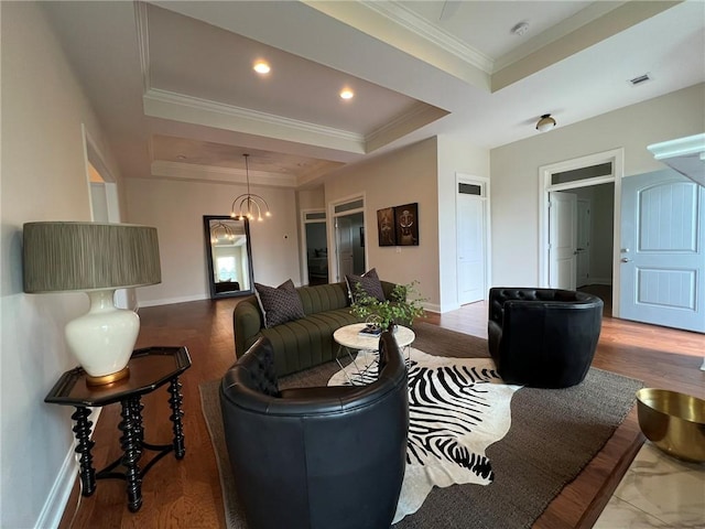living area featuring wood finished floors, visible vents, crown molding, a tray ceiling, and baseboards