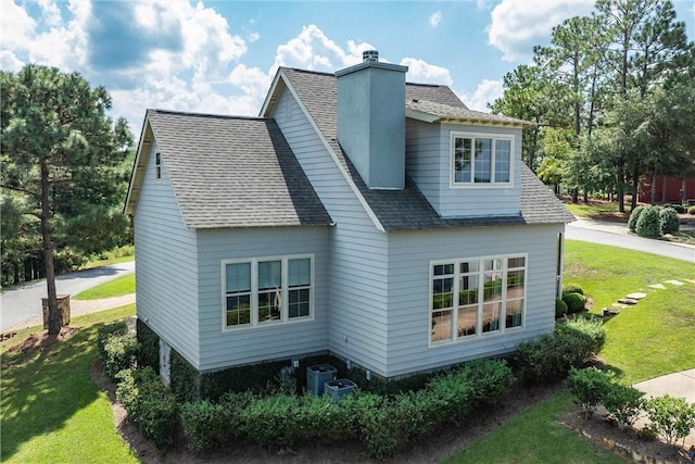 view of property exterior featuring cooling unit and a lawn