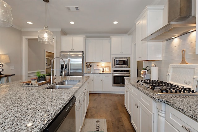 914 E Towne Lake Cir, Opelika, AL 36804 - kitchen featuring appliances with stainless steel finishes, wall chimney range hood, a sink, white cabinets, and ornamental molding