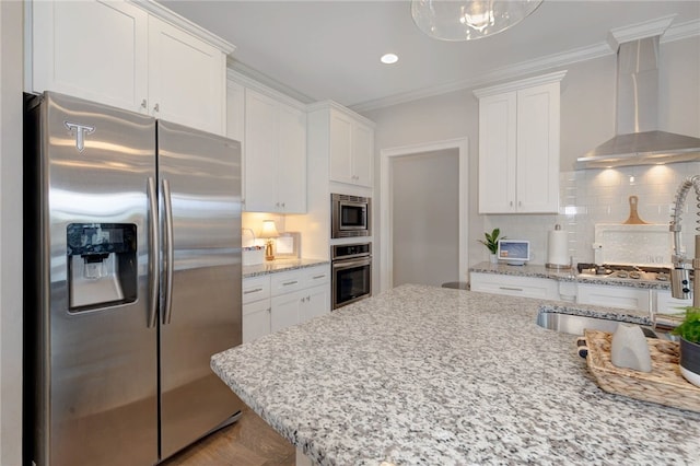 914 E Towne Lake Cir, Opelika, AL 36804 - kitchen with appliances with stainless steel finishes, wall chimney exhaust hood, white cabinets, crown molding, and backsplash