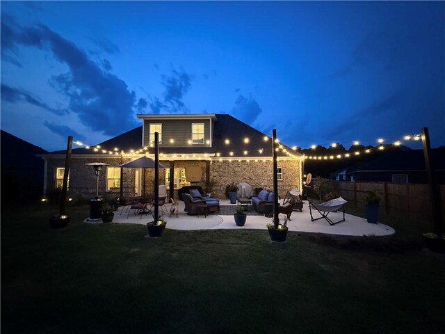 914 E Towne Lake Cir, Opelika, AL 36804 - back of house at night featuring a patio area