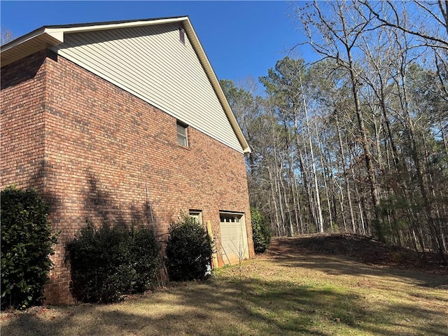 view of property exterior featuring driveway, brick siding, and an attached garage