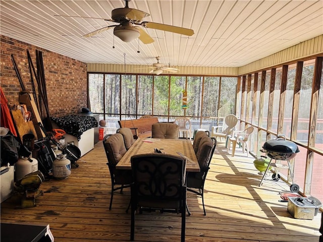 unfurnished sunroom with ceiling fan, wood ceiling, and a wealth of natural light