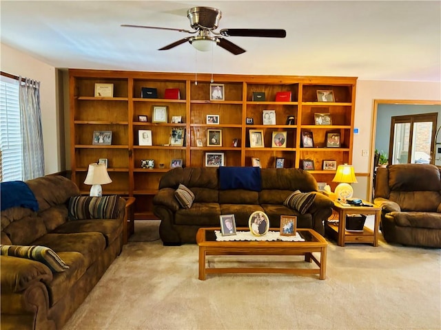 living area featuring light carpet and a ceiling fan