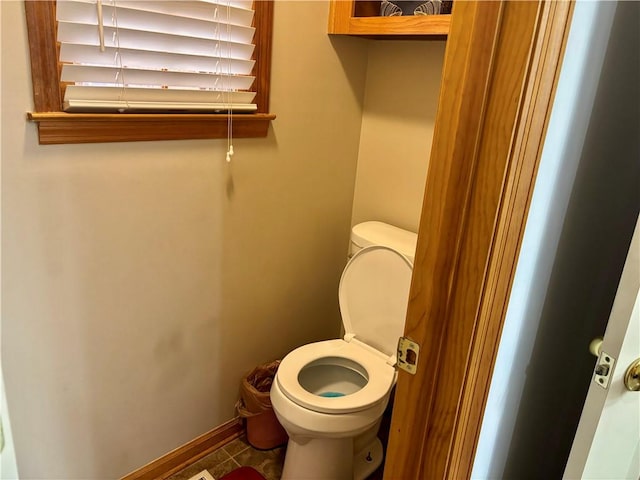 bathroom featuring toilet, tile patterned flooring, and baseboards