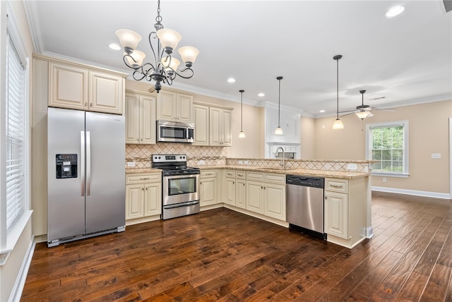 kitchen with cream cabinetry, decorative backsplash, a peninsula, appliances with stainless steel finishes, and dark wood-style flooring