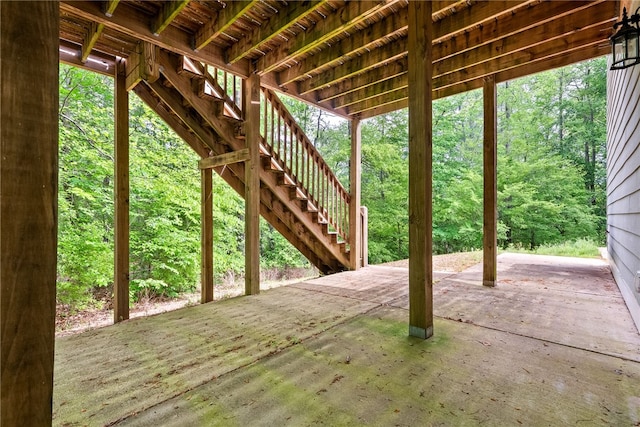view of patio with stairway and a wooded view