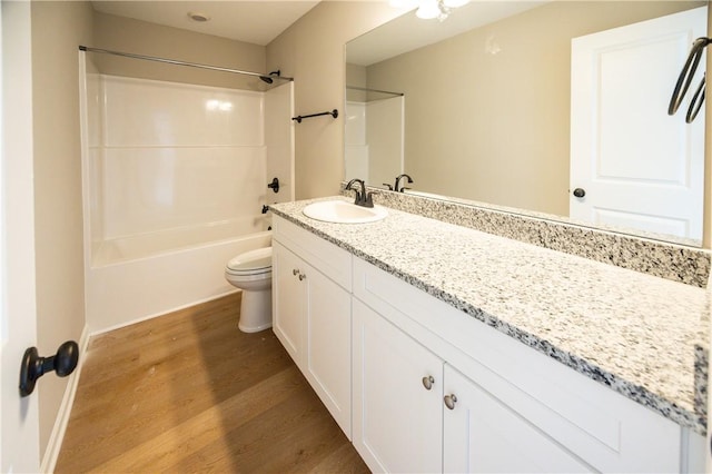 full bathroom with vanity, wood-type flooring,  shower combination, and toilet