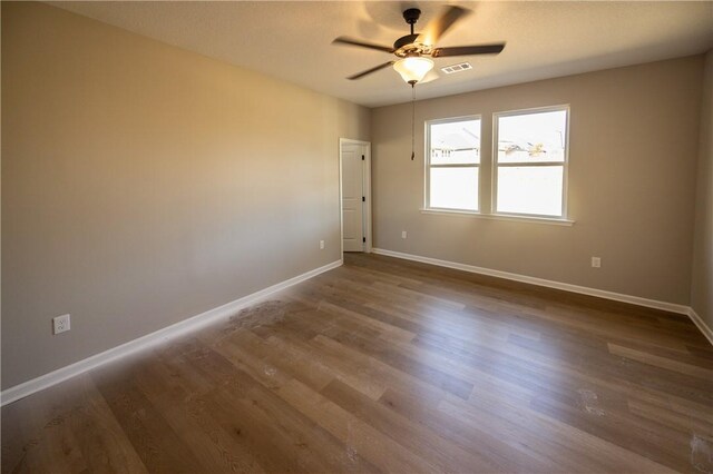 empty room with dark hardwood / wood-style flooring and ceiling fan