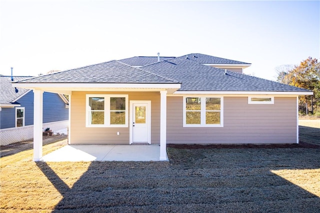 rear view of house with a yard and a patio