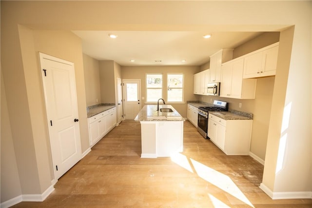 kitchen with white cabinets, sink, an island with sink, and appliances with stainless steel finishes