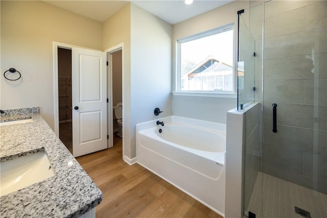 full bathroom featuring toilet, vanity, hardwood / wood-style flooring, and separate shower and tub