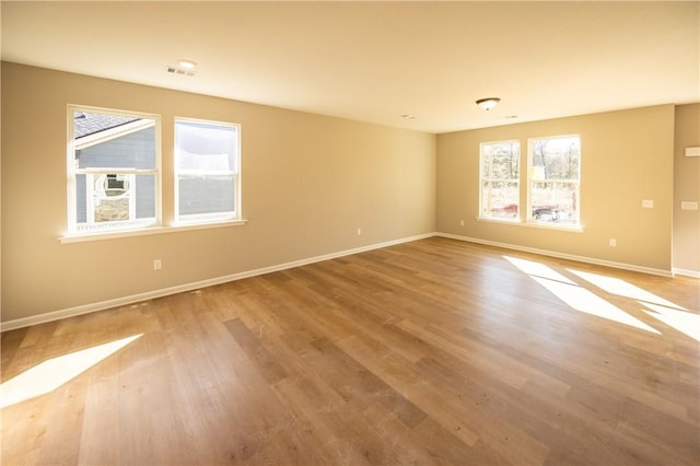 unfurnished room with hardwood / wood-style flooring and plenty of natural light