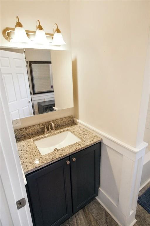 bathroom with a wainscoted wall, a decorative wall, and vanity
