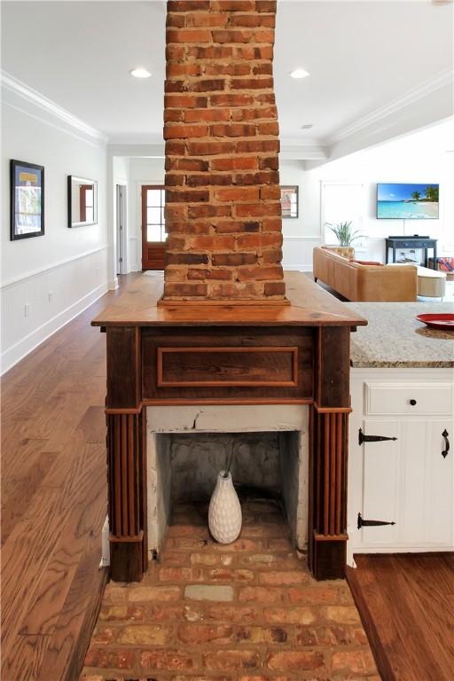 room details featuring a fireplace, recessed lighting, wood finished floors, and ornamental molding