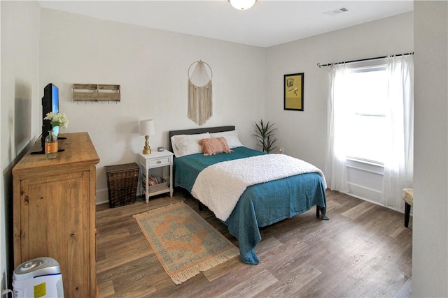 bedroom featuring visible vents and wood finished floors