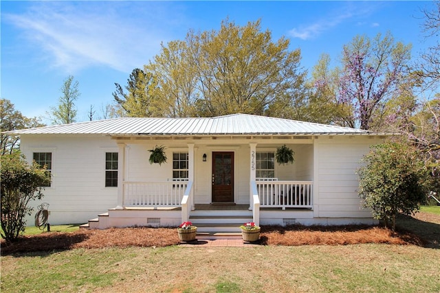 ranch-style house with covered porch, a front yard, crawl space, and metal roof
