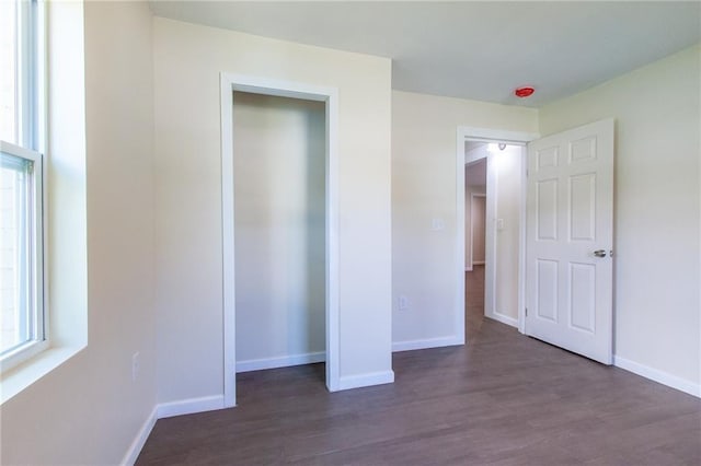 unfurnished bedroom featuring dark wood-type flooring and baseboards