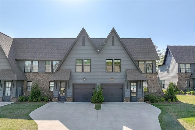 view of front facade featuring a garage, driveway, a shingled roof, and a front yard