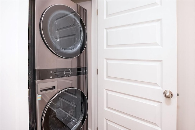 washroom featuring stacked washer and dryer and laundry area