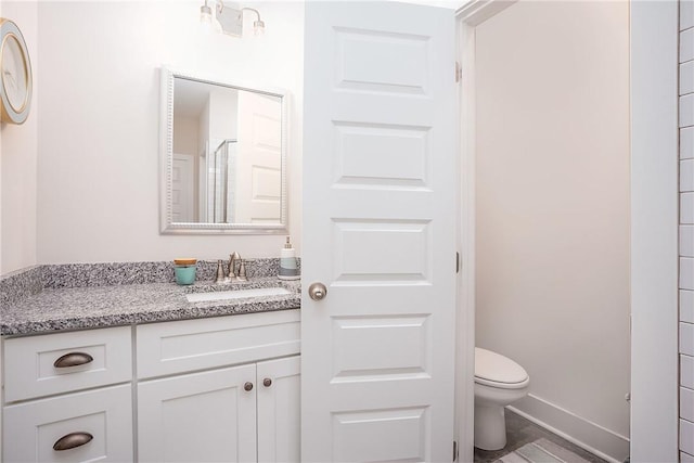 full bathroom with baseboards, toilet, and vanity