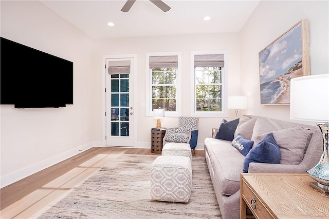 living room featuring ceiling fan, baseboards, light wood-style floors, and recessed lighting