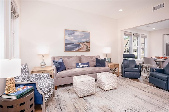living room with wood finished floors, visible vents, and recessed lighting