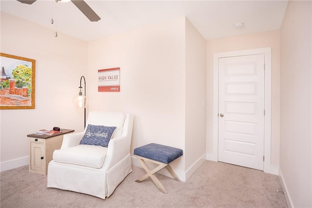 living area featuring a ceiling fan, baseboards, and carpet floors
