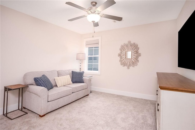 living area featuring baseboards, light colored carpet, and ceiling fan