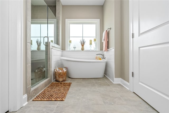bathroom with a stall shower and a freestanding tub