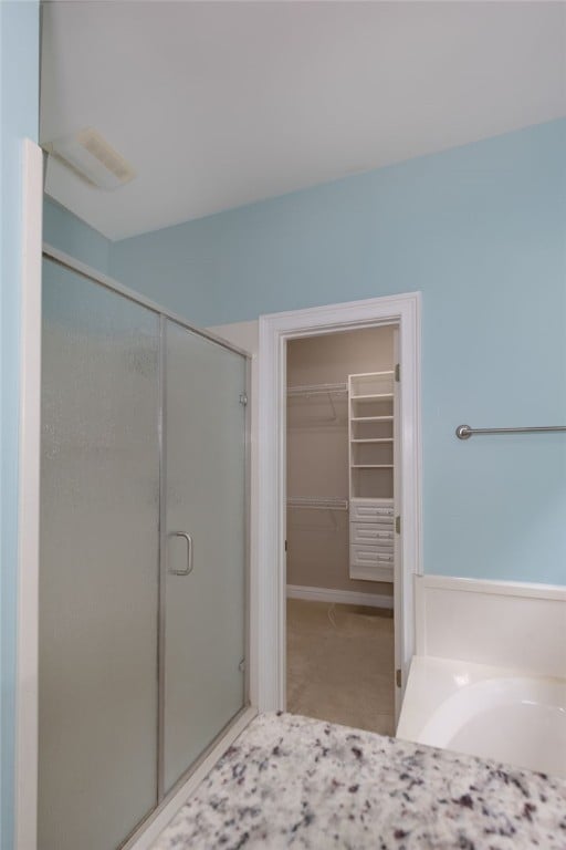 1761 Woodley Rd, Auburn, AL 36830 - full bathroom featuring a stall shower, a spacious closet, and a garden tub