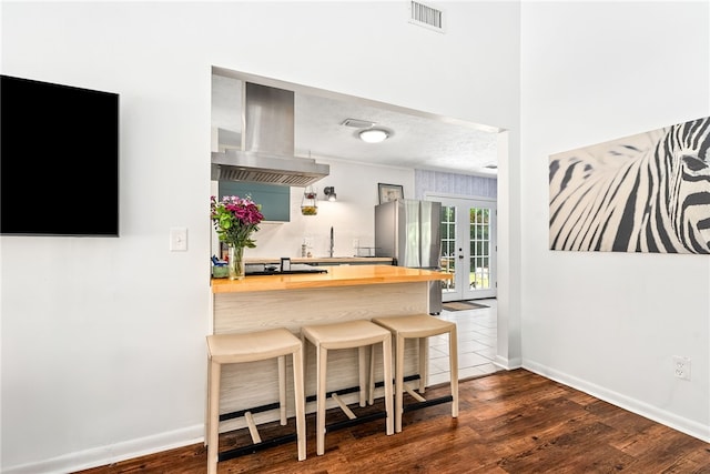 333 Tullahoma Dr, Auburn, AL 36830 - kitchen featuring butcher block counters, exhaust hood, a sink, a breakfast bar area, and dark wood-style floors