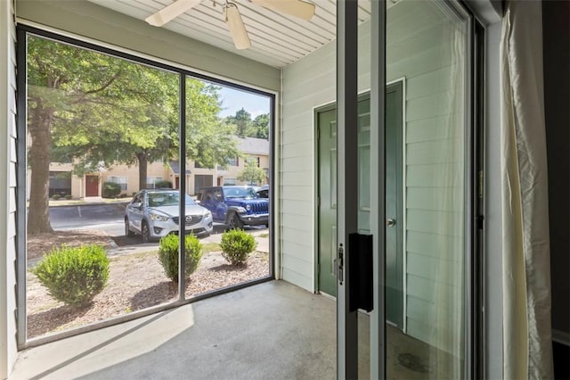 unfurnished sunroom with ceiling fan