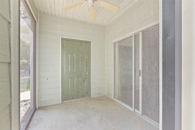 unfurnished sunroom with ceiling fan