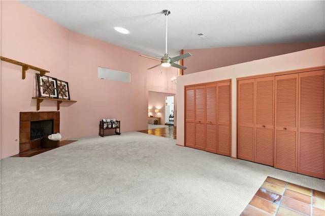 1115 Willow Run, Opelika, AL 36801 - unfurnished living room featuring vaulted ceiling, a ceiling fan, a tiled fireplace, and carpet