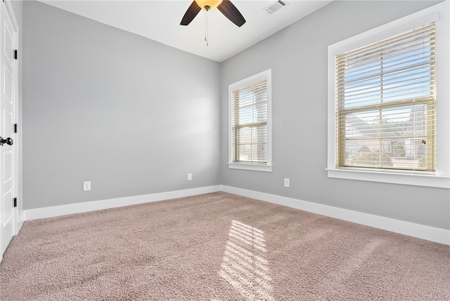 spare room featuring carpet floors, a healthy amount of sunlight, and ceiling fan