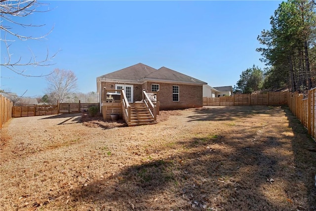 rear view of property featuring a deck and a fenced backyard