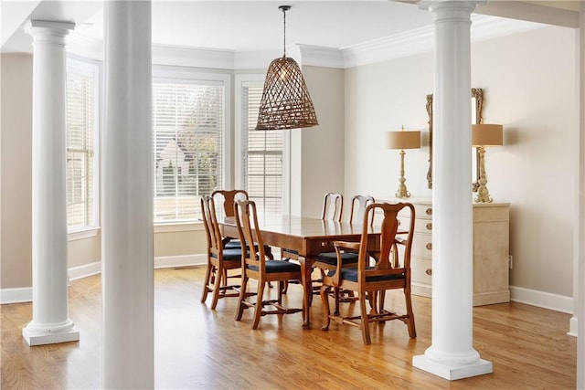 dining room featuring ornate columns, crown molding, and light hardwood / wood-style flooring