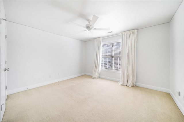 empty room featuring ceiling fan and light colored carpet