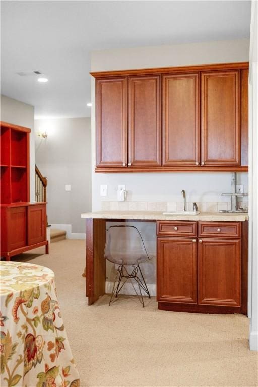 kitchen featuring light colored carpet and sink