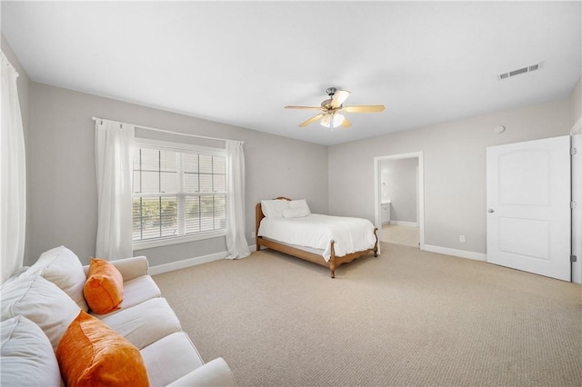 carpeted bedroom with ceiling fan and ensuite bath