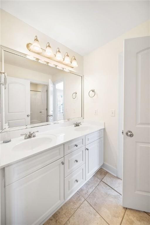 bathroom with tile patterned flooring, vanity, and a shower