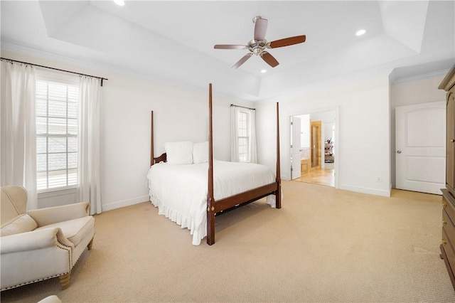 carpeted bedroom featuring crown molding, ceiling fan, a tray ceiling, and ensuite bath