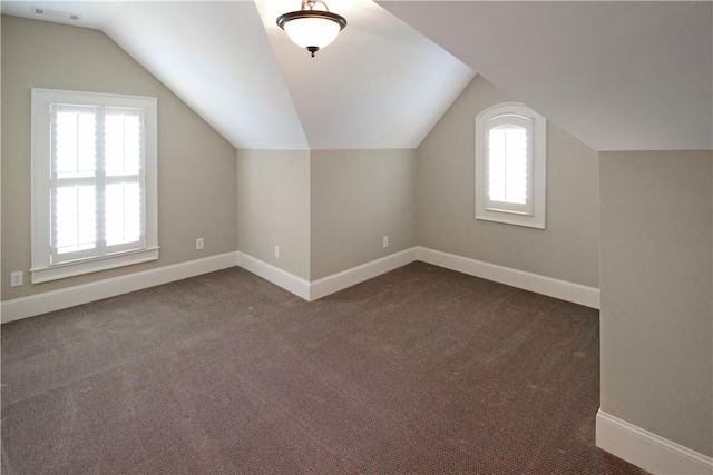 2904 Lone Eagle Ln, Opelika, AL 36801 - additional living space with healthy amount of natural light, vaulted ceiling, baseboards, and dark carpet