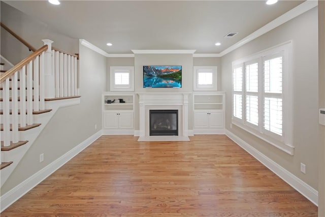 2904 Lone Eagle Ln, Opelika, AL 36801 - unfurnished living room featuring plenty of natural light, stairway, crown molding, a fireplace with flush hearth, and recessed lighting