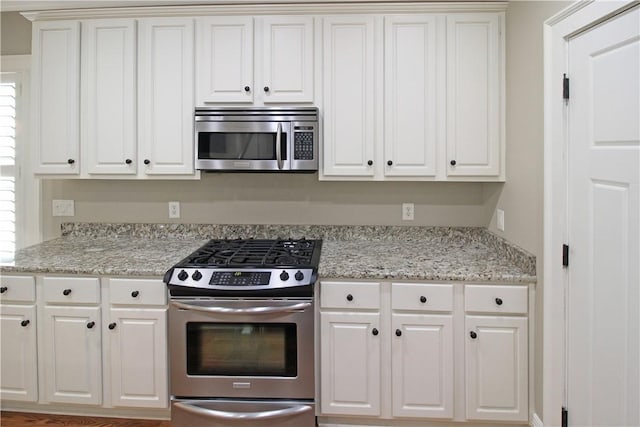 2904 Lone Eagle Ln, Opelika, AL 36801 - kitchen featuring stainless steel appliances, white cabinetry, and light stone counters