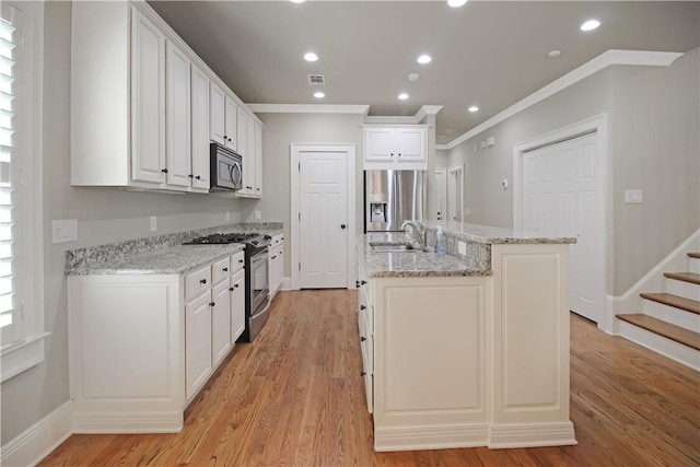 2904 Lone Eagle Ln, Opelika, AL 36801 - kitchen featuring stainless steel appliances, crown molding, a sink, a kitchen island with sink, and white cabinets