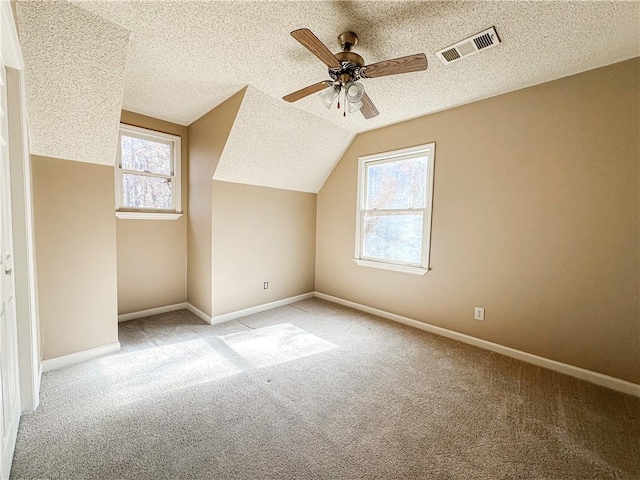 bonus room featuring plenty of natural light, ceiling fan, light colored carpet, and lofted ceiling