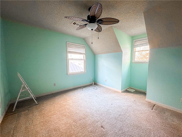 bonus room with a textured ceiling, ceiling fan, light carpet, and vaulted ceiling